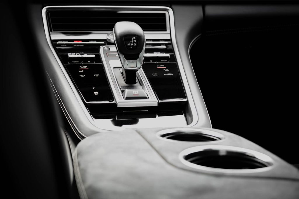 Close-up view of a modern car gearshift knob inside a monochrome vehicle interior.